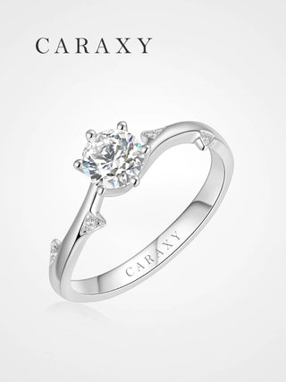 Nature-inspired engagement ring with a brilliant round center diamond and leaf accent diamonds.