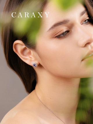 Model wearing oval cornflower blue sapphire stud earrings with lab grown diamond halos, styled as elegant September birthstone jewelry.