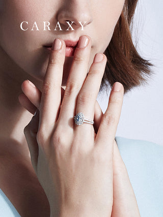 Close-up on finger showing the brilliant scale of an oval double halo blue diamond ring.