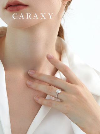 Lifestyle view of a model wearing an oval halo engagement ring to show scale.