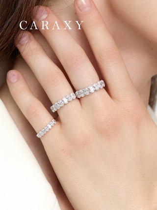 Hand wearing three oval lab grown 7 stone diamond bands in 0.4, 0.6, and 1.3 ct t.w.