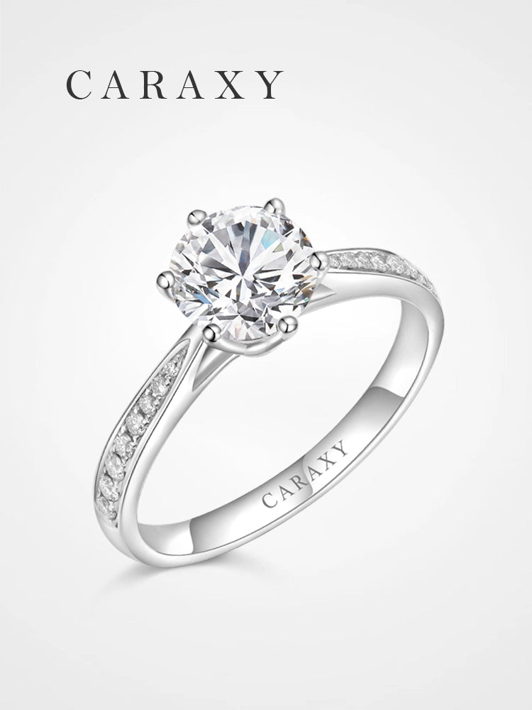 A six-prong engagement ring with a shimmering pavé diamond band.