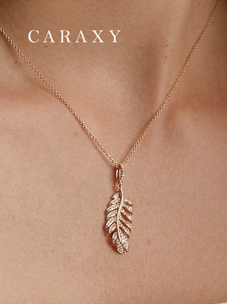 Detailed view of a pavé diamond feather necklace worn on model, featuring a nature-inspired pendant.