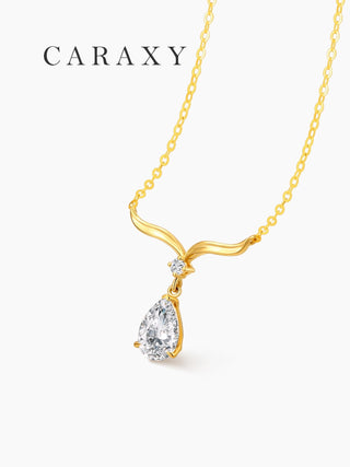 Angled view of a pear-shaped lab grown diamond necklace in yellow gold with a flowing wing-inspired gold detail.