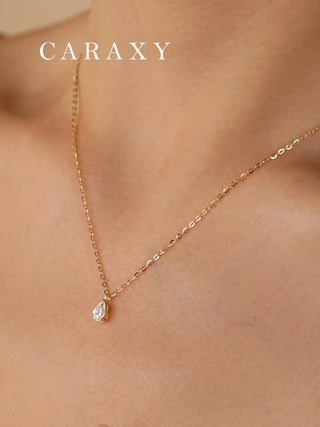Pear shaped lab grown diamond solitaire pendant necklace in 18K yellow gold worn on a model.