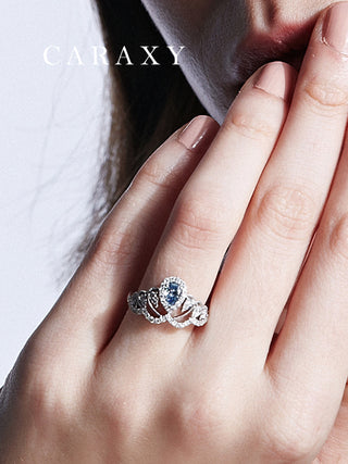 Close-up on finger showing the brilliant blue fire of a pear-cut diamond statement ring.