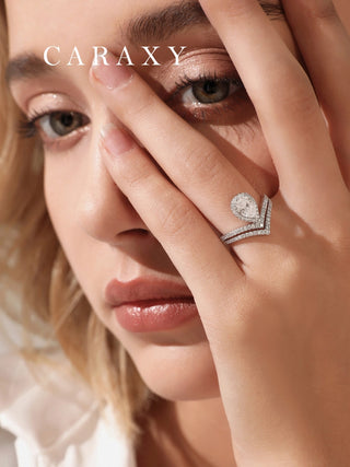 Lifestyle view of a model wearing a large pear halo engagement ring to show scale.