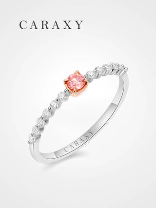 Angled view of a pink diamond engagement ring with a delicate round shared-prong diamond band