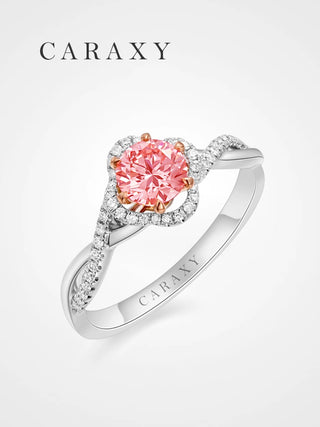 A romantic pink diamond engagement ring with a floral halo and twisted pavé band.