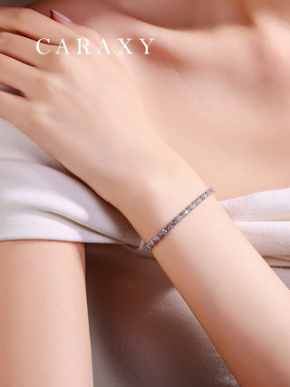 Model wearing a platinum round lab grown diamond X-link tennis bracelet.