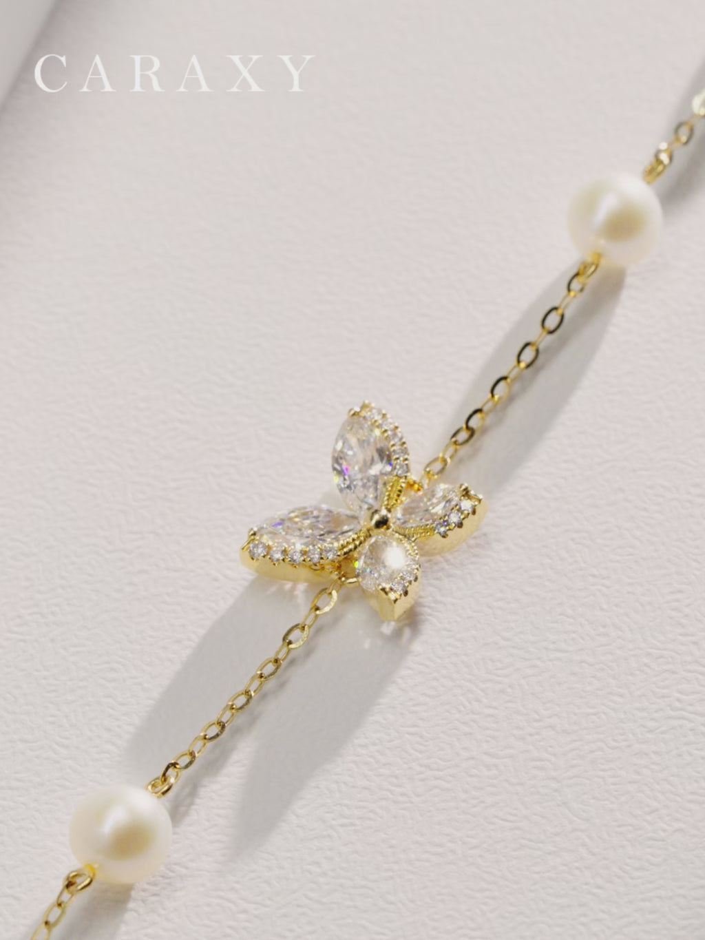 Video showing the details and fit of an adjustable 18K yellow gold butterfly bracelet featuring marquise-cut lab-grown diamonds and four freshwater pearls.