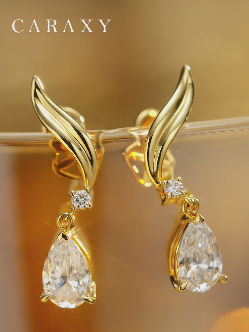 18K gold teardrop diamond earrings shown.