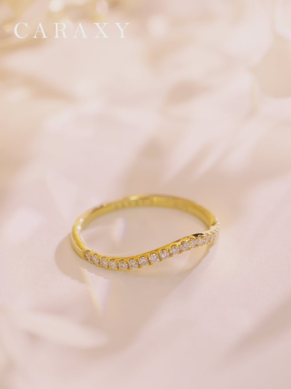 Close-up video of the curved lab-grown diamond wedding band in 18K yellow and white gold, showing the half-pavé round diamonds, subtle chevron contour, slim side profile, and how the ring looks worn alone and paired with other rings.