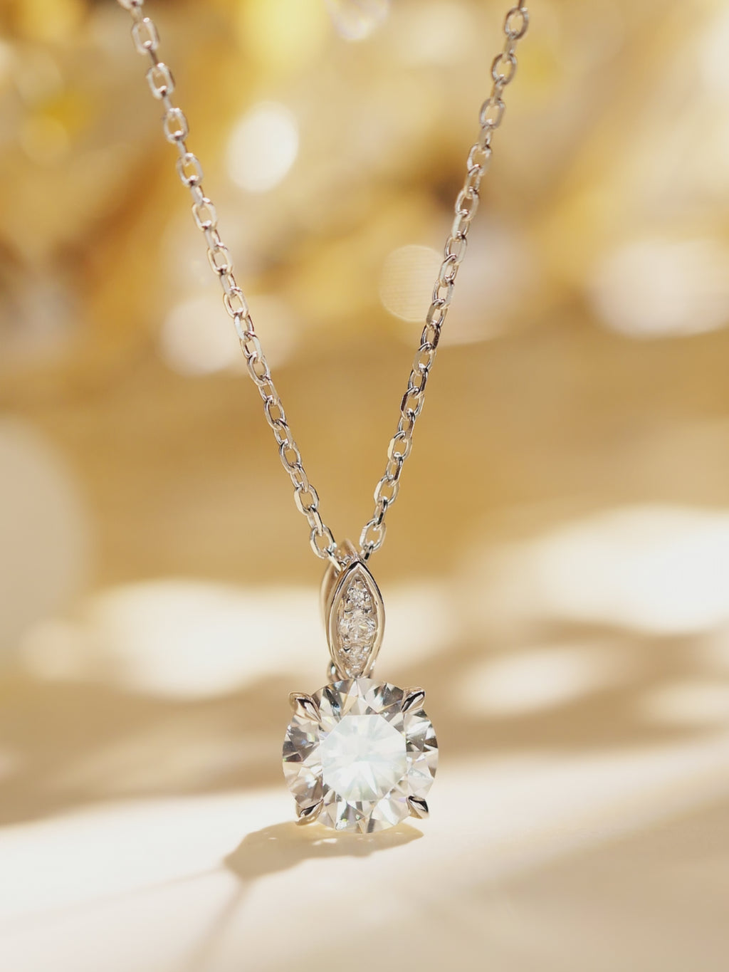 Multi-angle view of an 18K white gold round lab-grown diamond solitaire necklace.