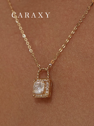 Close-up of a model wearing a lab grown diamond lock pendant necklace in 18K yellow gold with a round brilliant center stone, halo frame, and four-prong setting.