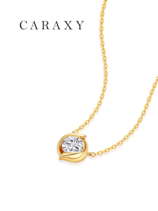 Angled view of a round lab-grown diamond seed pendant in 18K yellow gold