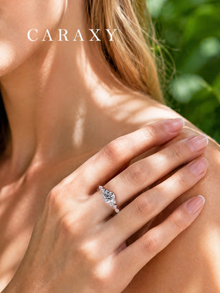 Nature-inspired round diamond side stone engagement ring shown on hand