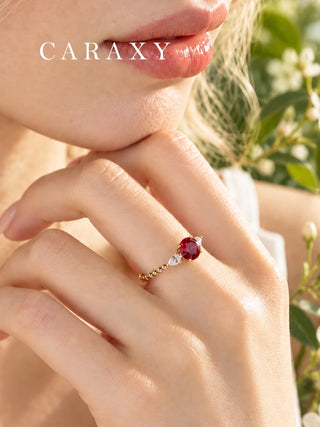 Close-up of a round ruby and diamond ring worn on the hand
