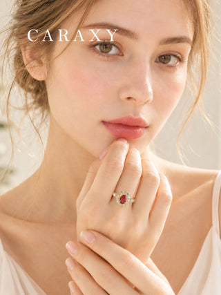 Close-up of an oval lab grown ruby diamond engagement ring worn on the hand