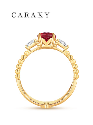 Profile view of a ruby and pear diamond ring with a beaded yellow gold shank