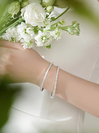 Stackable lab grown diamond half bangle bracelet worn on the wrist in a layered fine jewelry look.