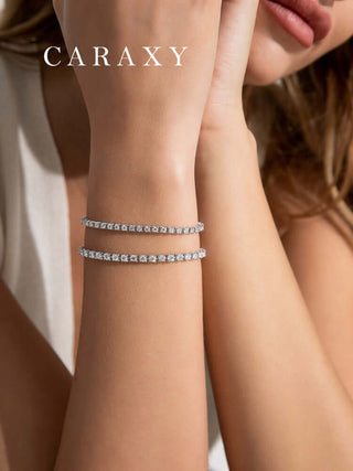 Two round diamond tennis bracelets stacked on the wrist for an elegant layered look.