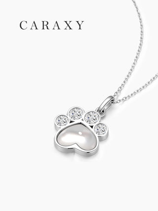 Side view of sterling silver paw inspired diamond pendant necklace with mother of pearl center and bezel setting.