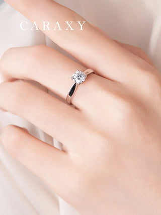 Close-up of a classic cathedral solitaire ring on hand showcasing its elegant tapered band.