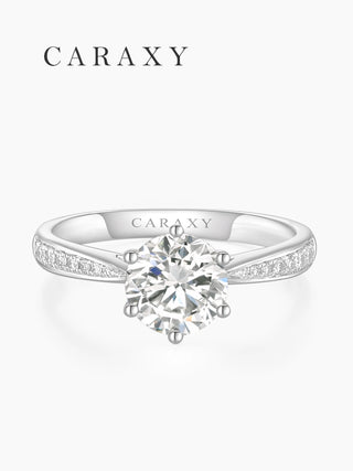 Top view of a 1 carat solitaire ring with a tapered pavé band in 18K white gold.