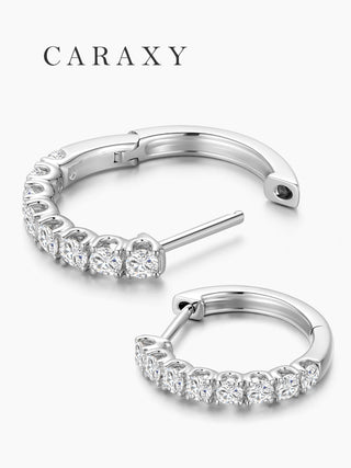 Open view of white gold diamond huggie earrings showing the curved hoop design.