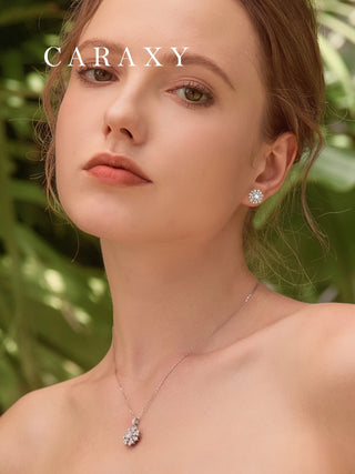 A woman wearing a round diamond halo earrings and matched necklace.