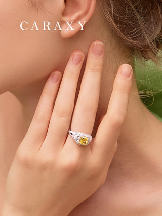 Close-up on finger showing the brilliant sparkle of a yellow diamond ring with marquise band.