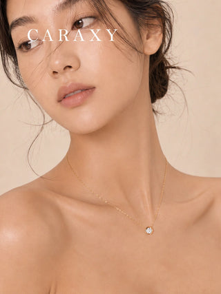 Woman wearing an 18K yellow gold diamond pendant necklace at the neckline